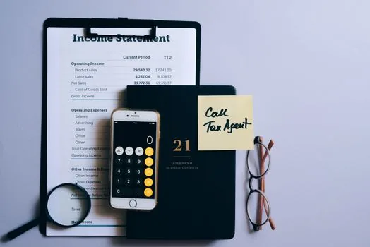a small Korean shop owner's desk with a calculator, tax documents and a coffee cup, warm afternoon light through the window, editorial photography, shallow depth of field