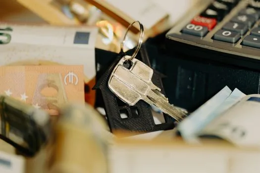 a stack of korean won banknotes and a small calculator beside a coffee cup on a desk, soft daylight, editorial finance photography, shallow depth of field