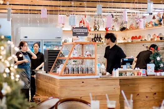 korean small shop interior with an employee organizing inventory, warm cozy atmosphere, no faces, over-the-shoulder wide shot, editorial photography