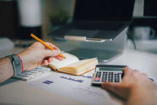 employee onboarding documents, payroll calculator and business certificate on a clean Korean office desk, realistic photo | 첫 직원 입사 서류와 급여 자료를 한곳에 모아둔 장면
