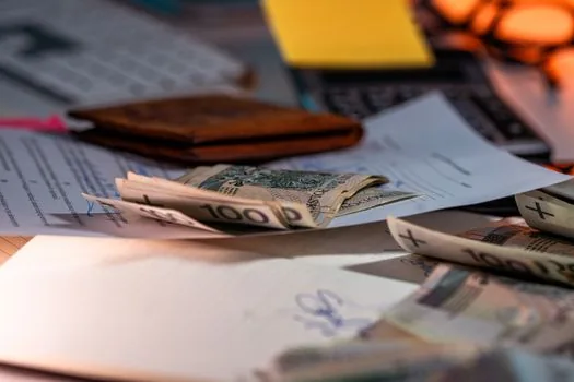 hands organizing korean won bills and a savings ledger on a table, calm and thoughtful mood, natural indoor light, editorial photography, no text