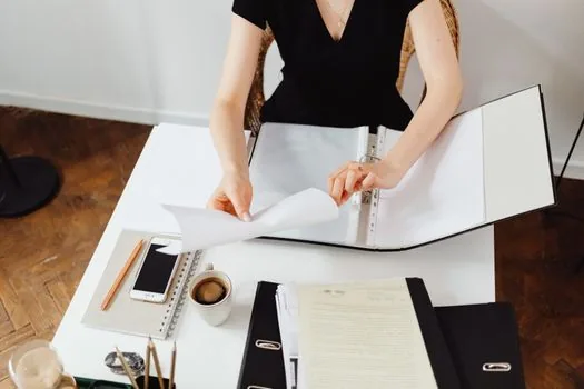 Korean cafe owner preparing part time employee roster, contract and payroll binder