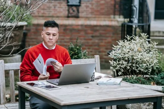 Korean founder reviewing tax certificate request email and Hometax menu on laptop