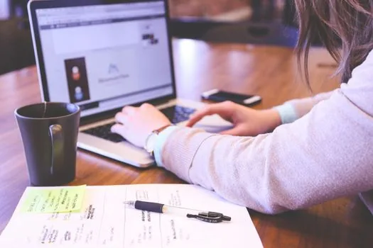 Korean online seller checking business address change documents on laptop