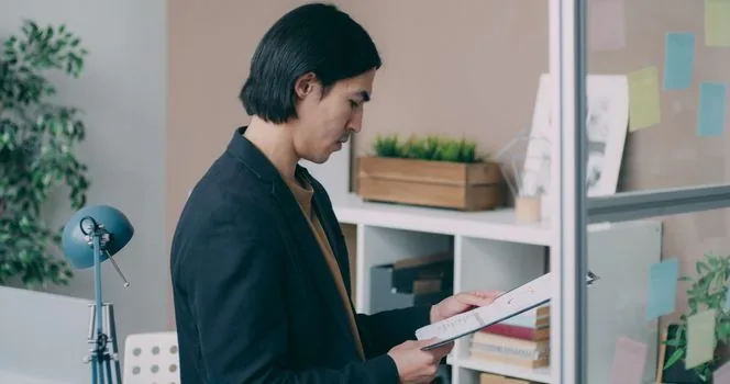 Korean startup founder checking tax documents and business plan in small office