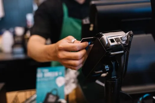 small business owner checking point of sale terminal