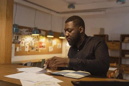 small shop manager comparing part time schedule, wage sheet and employee roster