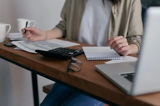 accountant checking invoice issue date, contract cancellation memo and tax calendar on desk, realistic office photo, no logos