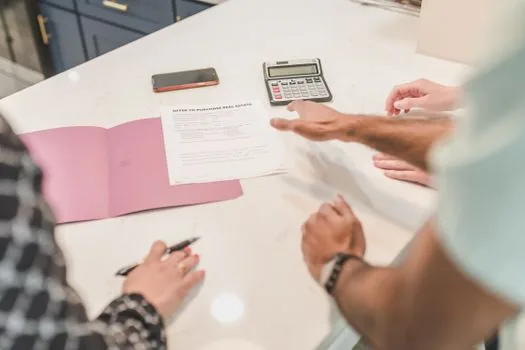 business owner checking pension support fee waiver notes beside calculator and employee contract