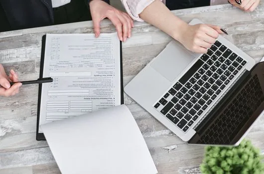 business owner reviewing tax invoice correction checklist and transaction statement on laptop, bright Korean office desk, no logos, no faces
