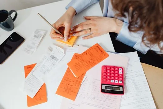 Capital deposit bankbook, balance certificate memo and calculator beside incorporation documents, realistic Korean startup office desk | 자본금 통장과 잔액증명 준비사항을 확인하는 모습