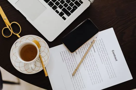 Close up of signed employment contract, envelope for employee copy and digital folder on laptop, realistic Korean small office compliance photo | 서명한 근로계약서와 교부 기록을 함께 보관하는 모습