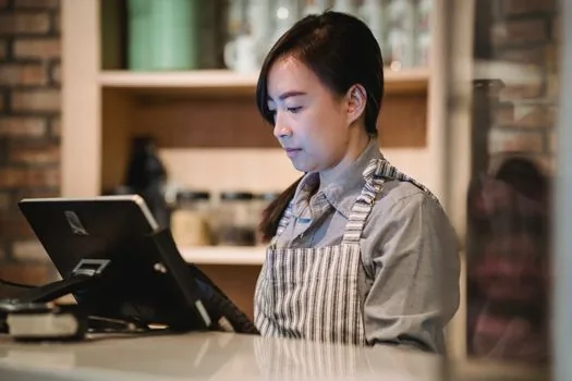 Hometax registration checklist on laptop with POS terminal and business license documents, bright Korean small office | 현금영수증 가맹점 가입 전 홈택스와 사업자 서류를 확인하는 모습