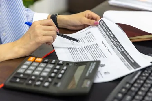 Korean accountant and small business owner reviewing original withholding tax PDF and correction checklist on laptop, realistic office daylight photo