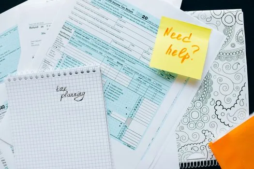 Korean business owner marking business closure month and retirement payment statement deadline on tax calendar, document checklist on desk, realistic photo no text