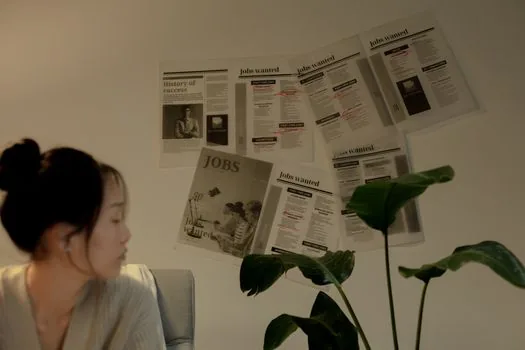 Korean business owner reviewing domestic job posting history and hiring calendar beside factory floor, laptop and paper checklist, realistic office photo | 내국인 구인 노력 기록과 접수 일정을 대조하는 장면