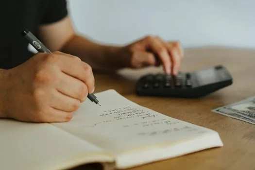 Korean business owner sorting property list, lease contract, resident registration memo, and tax calculator on office desk