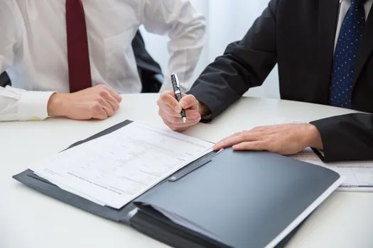 Korean employer reviewing employment contract, insurance checklist and payroll folder with calculator, clean office table, realistic documentary photo
