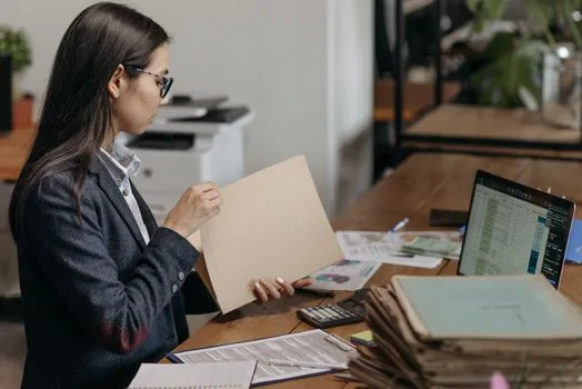 Korean founder arranging corporate seal, capital bankbook and incorporation checklist beside laptop, bright office desk, realistic startup documentation photo | 법인설립 전 법인인감과 자본금 통장을 함께 준비하는 모습
