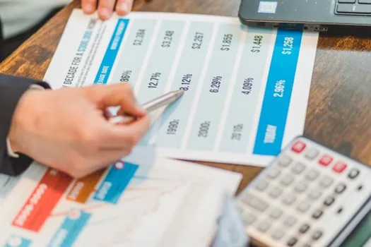 Korean founder checking cashflow spreadsheet beside stock market liquidity chart