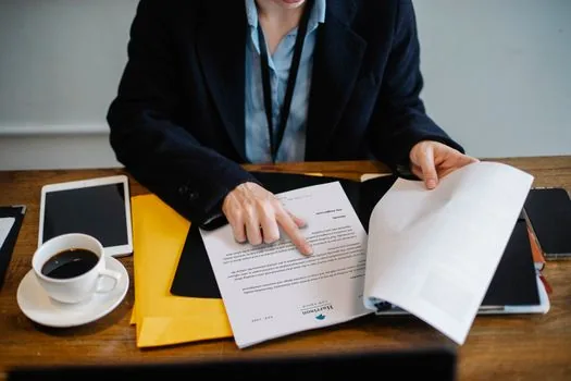 Korean founder reviewing personal brand sponsorship proposal with press clippings and clean contract documents on desk, bright realistic office photo, no readable logos | 개인 브랜드 협찬 제안서 검토 장면 | 공개 수상 이력을 사업 자료로 정리하는 예시 이미지