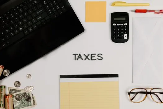 Korean freelancer contract, withholding tax memo and payment transfer receipt being checked on office laptop, realistic photo | 프리랜서 계약서와 원천징수 메모를 대조하는 장면