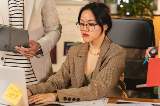 Korean office manager replying to former employee email about retirement income withholding receipt, payroll documents organized on desk, realistic bright office photo