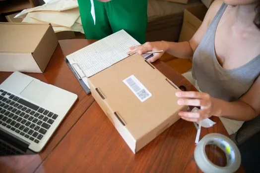 Korean shop owner checking changed business name on certificate, invoice folder, and online store seller profile, bright office desk | 상호 변경 후 사업자등록증과 판매자 정보를 대조하는 장면