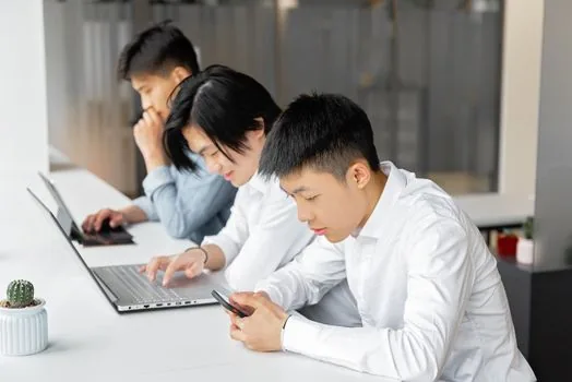 Korean small business owner checking tax notice alert on smartphone and laptop