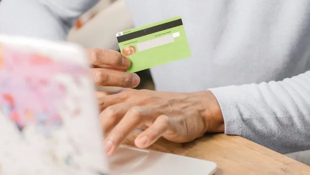 Korean small business owner comparing business credit card list with Hometax menu path on laptop and smartphone, realistic desk photo | 홈택스와 손택스 등록 경로를 확인하며 카드 목록을 정리하는 장면