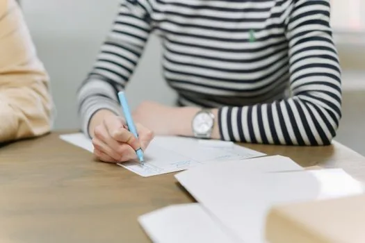Korean small business owner highlighting support program notice, employee roster and calendar baseline date on bright office desk, realistic documentation photo | 지원사업 공고문의 기준일과 제출서류명을 먼저 표시하는 장면
