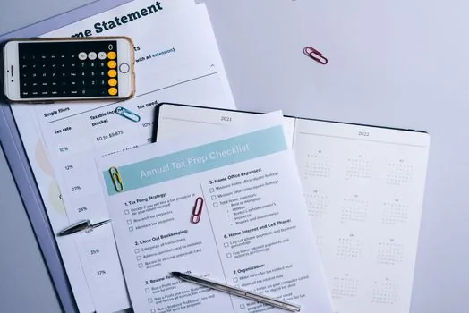 Korean small business payroll ledger on desk with calendar marked tax deadline, laptop and calculator, bright realistic office photography, no logos, no readable text