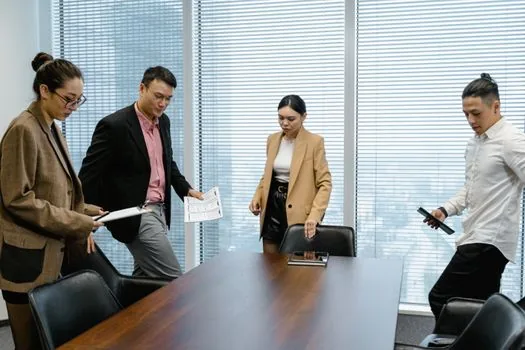Korean small business team arranging replacement worker schedule and workload sharing allowance documents, realistic editorial photo