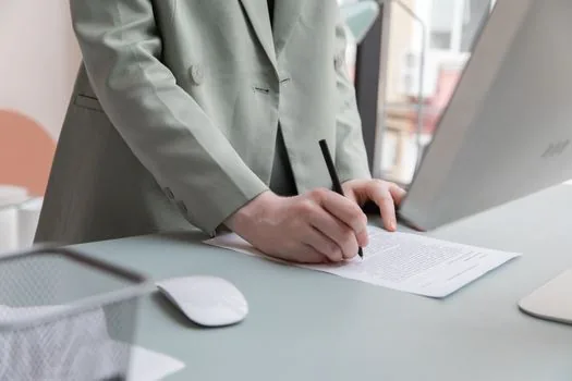 Korean small company CEO checking employee count sheet and employment rules folder on bright office desk | 상시근로자 수와 취업규칙 초안을 함께 확인하는 장면