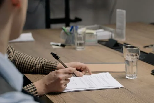 Korean small landlord reviewing basement lease contract, flood barrier consent form, and housing support checklist on desk, realistic Seoul office photo no logos