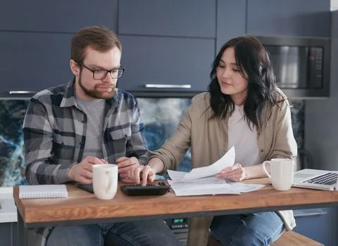 Korean sole proprietor reviewing Hometax electronic tax invoice login screen and sales ledger in a clean office