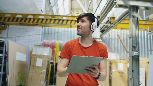 Korean startup founder checking basement office electrical outlets, inventory boxes raised on shelves, dehumidifier and insurance documents, realistic bright photo no logos