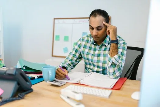 Korean startup founder organizing employee payroll ledger and retirement pension folder on office desk