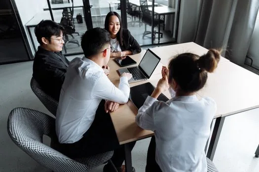 Korean startup team reviewing employment rules draft, change comparison table and worker signatures in a meeting room | 취업규칙 변경 전후 비교표와 직원 의견 자료를 검토하는 장면