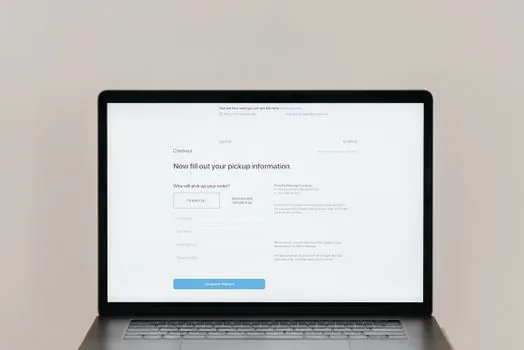 Online seller comparing settlement bankbook copy, business registration document, mail order license, and store footer information on laptop