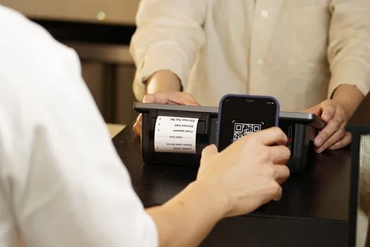 Simple Korean cashier notice template for local voucher payment rules beside receipt printer and calculator, realistic small business desk photo | 계산대 민생지원금 안내문 예시 | 결제 가능 여부와 환불 기준을 짧게 적는 장면