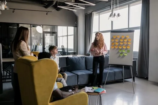 small business owner preparing workplace training handouts and employee notice board in bright office
