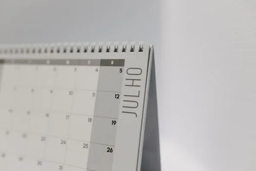 small company manager marking three month application periods and return to work date on calendar, realistic office photo