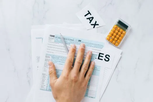 tax advisor comparing apartment market value report, capital gains tax sheet, and residence period checklist for Korean business owner
