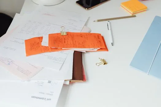vehicle logbook, fuel receipt, insurance paper, and depreciation limit note on accounting desk