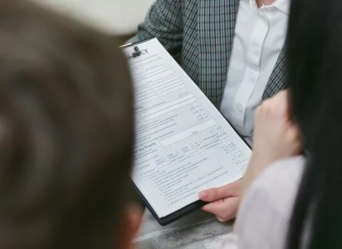 business owner organizing insurance policy PDF, local government notice and renewal checklist for restaurant lodging business, realistic office photo | 보험증권과 지자체 안내문을 한 폴더에 정리하는 장면