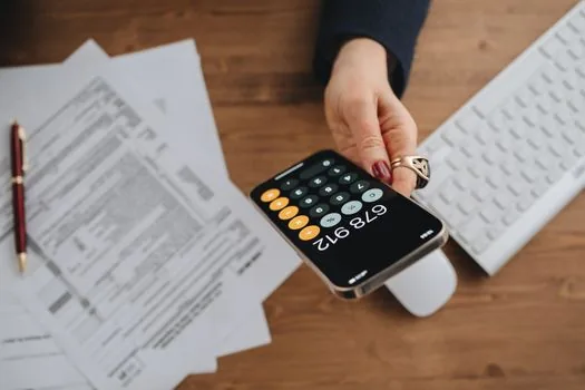 Korean accountant checking phone ARS note, tax office visit checklist and invoice documents beside laptop | ARS와 세무서 대리발급을 비상 경로로 정리하는 세무 업무 장면
