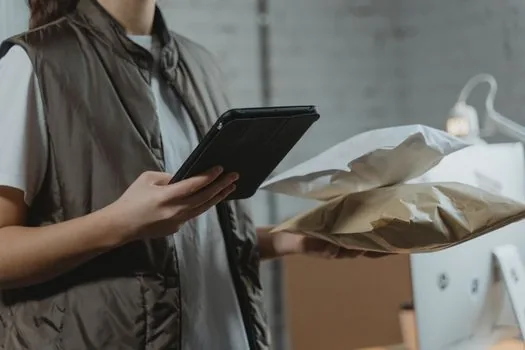 Korean accountant reviewing SNS sales receipts, parcel invoices, smartphone order messages with small business owner