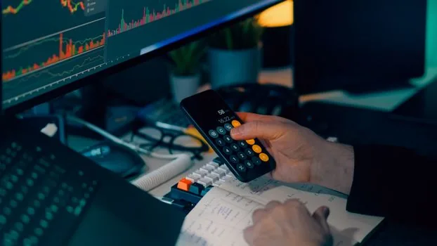 Korean business owner searching industry code by business keywords on laptop with tax notes and calculator | 업종명 키워드로 업종코드 후보를 좁히는 장면