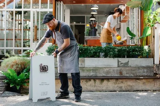 Korean cafe owner comparing signboard color draft, storefront facade photo and local permit checklist on a clean desk | 매장 대표가 간판 시안과 건물 전경사진을 함께 확인하는 장면